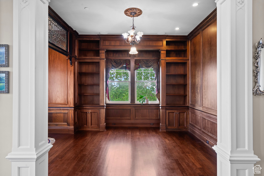 Unfurnished office featuring dark wood finished floors, a chandelier, built in features, and recessed lighting
