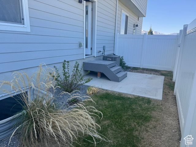 Fenced backyard featuring a patio and central AC unit