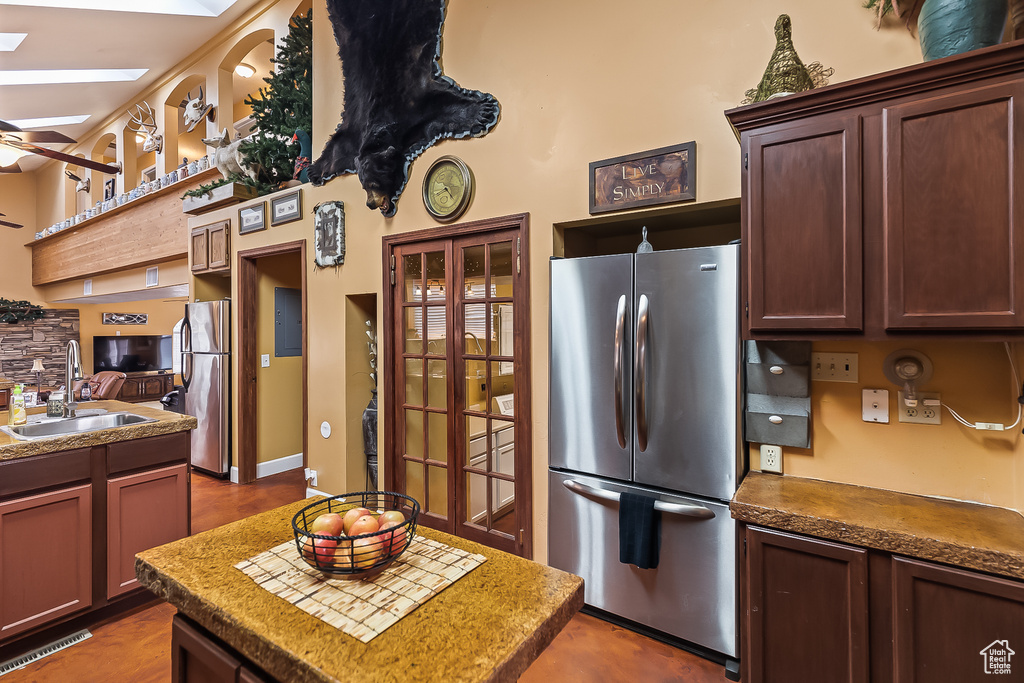 Kitchen with freestanding refrigerator, a sink, ceiling fan, and a kitchen island