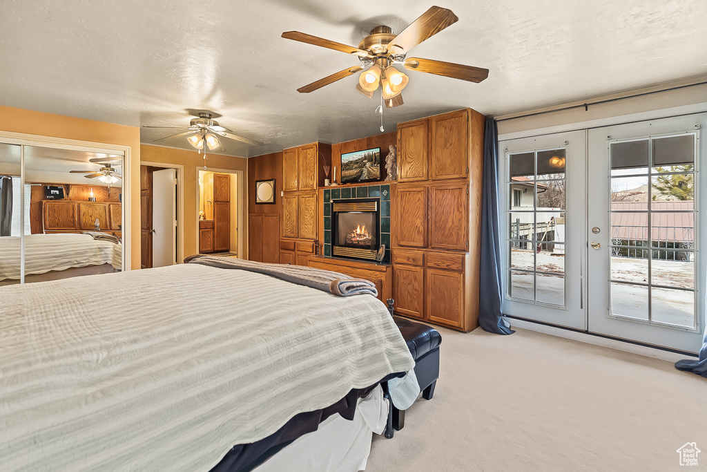 Bedroom featuring access to exterior, light carpet, french doors, and a ceiling fan