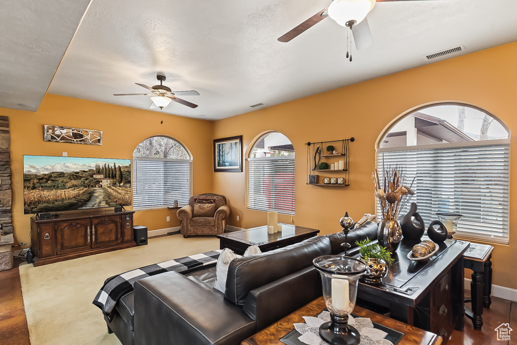 Living area featuring a ceiling fan and baseboards