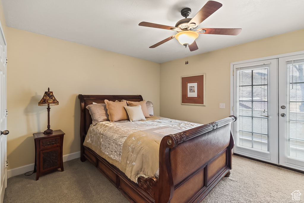 Bedroom featuring light colored carpet, access to outside, baseboards, and ceiling fan