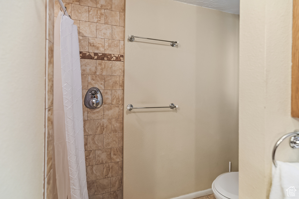 Full bath with a tile shower and toilet