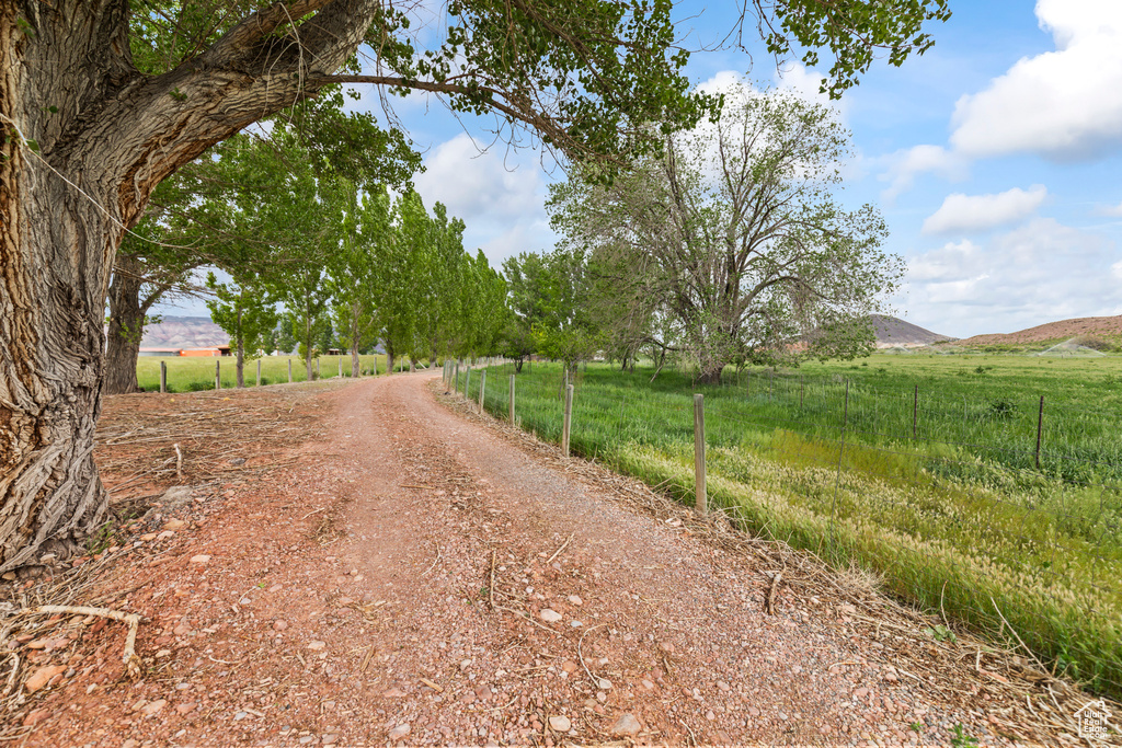 View of dirt / gravel road featuring a rural view and a mountain view
