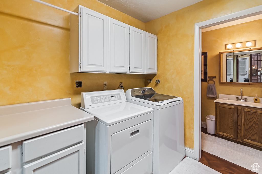 Laundry area featuring cabinet space, washer and dryer, and dark wood-style floors