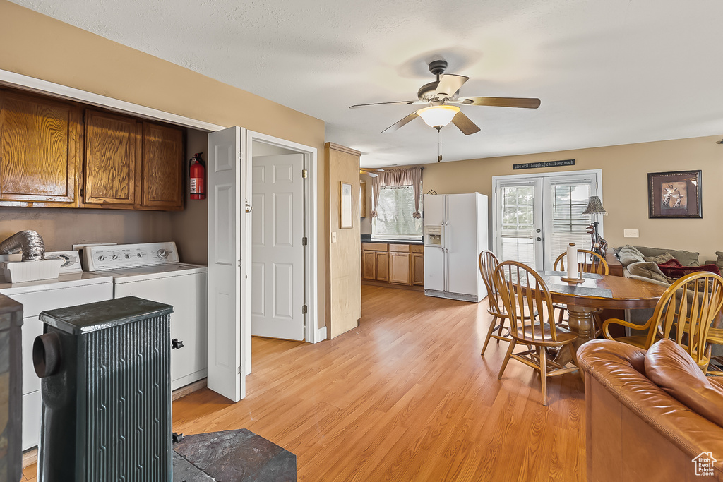 Dining room with separate washer and dryer, ceiling fan, and light wood-style floors