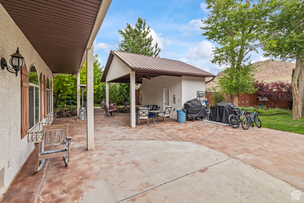 View of patio featuring ceiling fan, outdoor dining area, and a grill