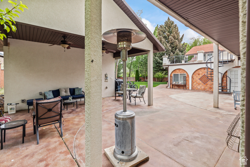 View of patio featuring an outdoor hangout area, stairway, and ceiling fan