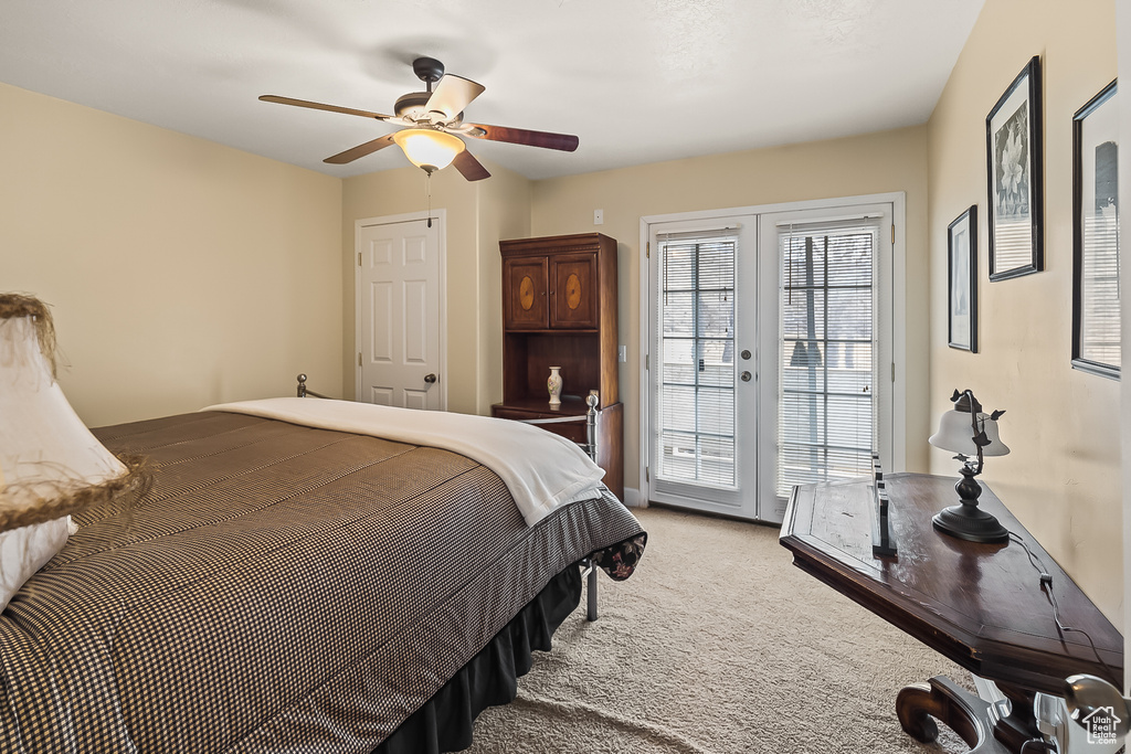 Bedroom with access to outside, light colored carpet, ceiling fan, and french doors