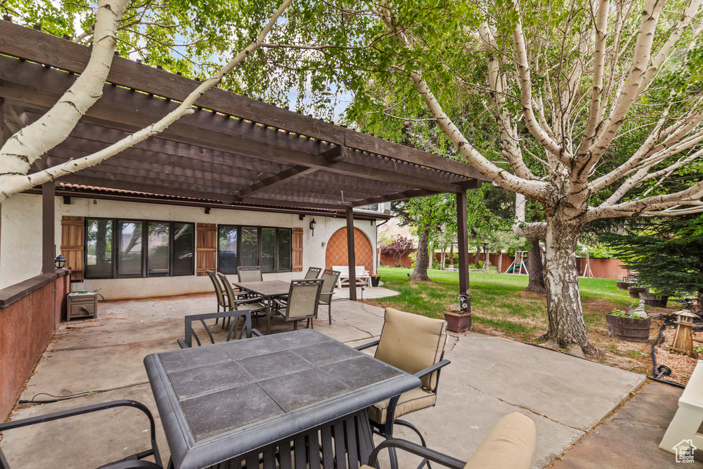 View of patio / terrace featuring outdoor dining space, a pergola, and a playground