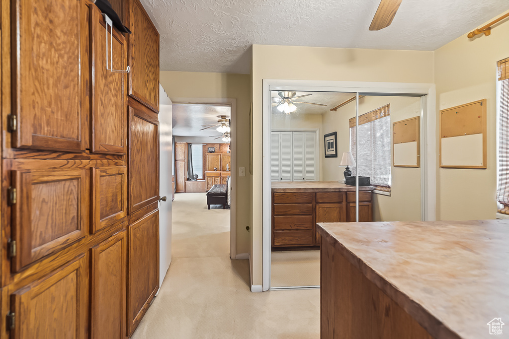Bathroom featuring a ceiling fan and a textured ceiling