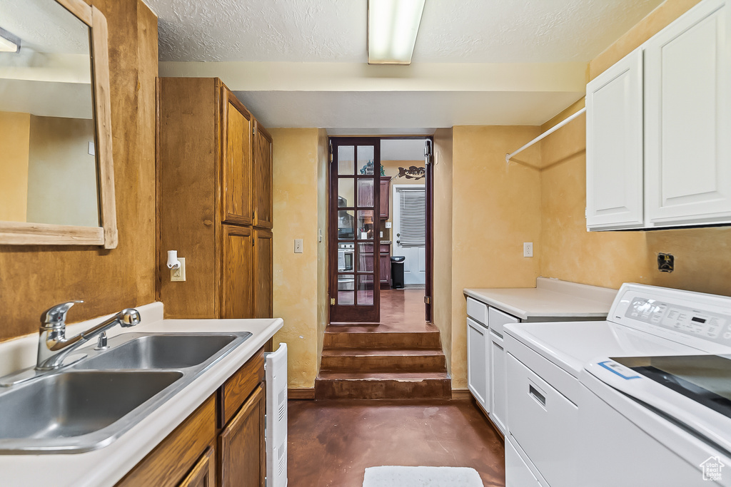 Washroom with cabinet space, separate washer and dryer, and a textured ceiling