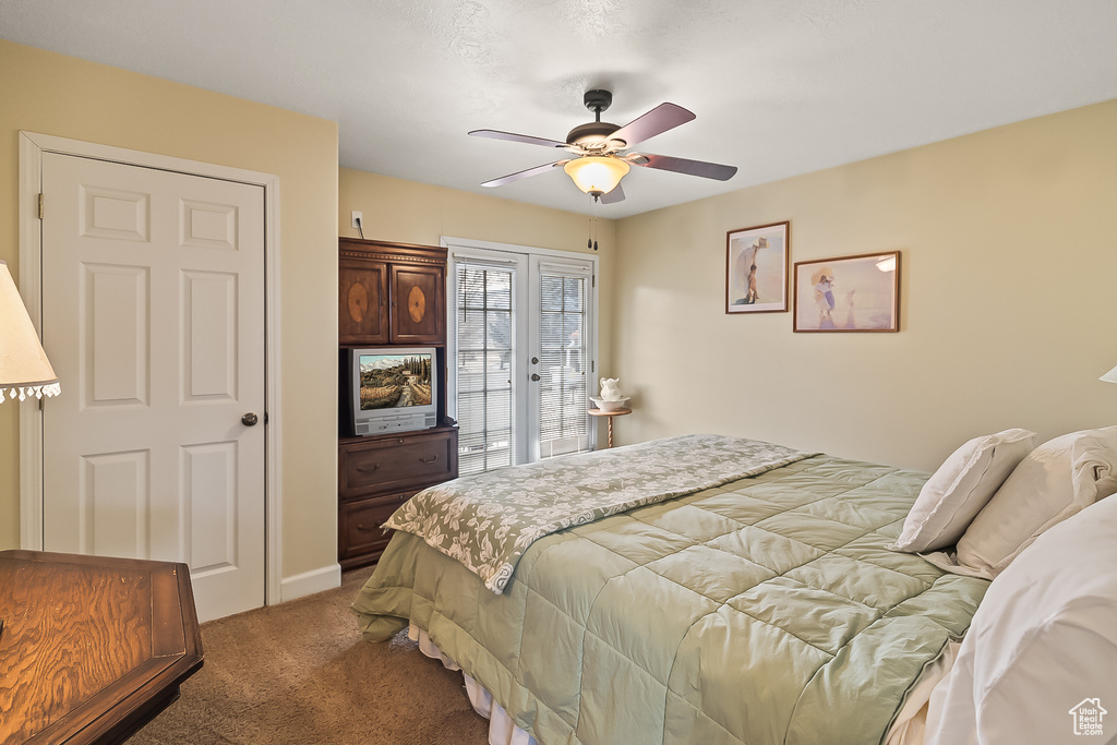 Carpeted bedroom featuring access to outside, ceiling fan, and baseboards