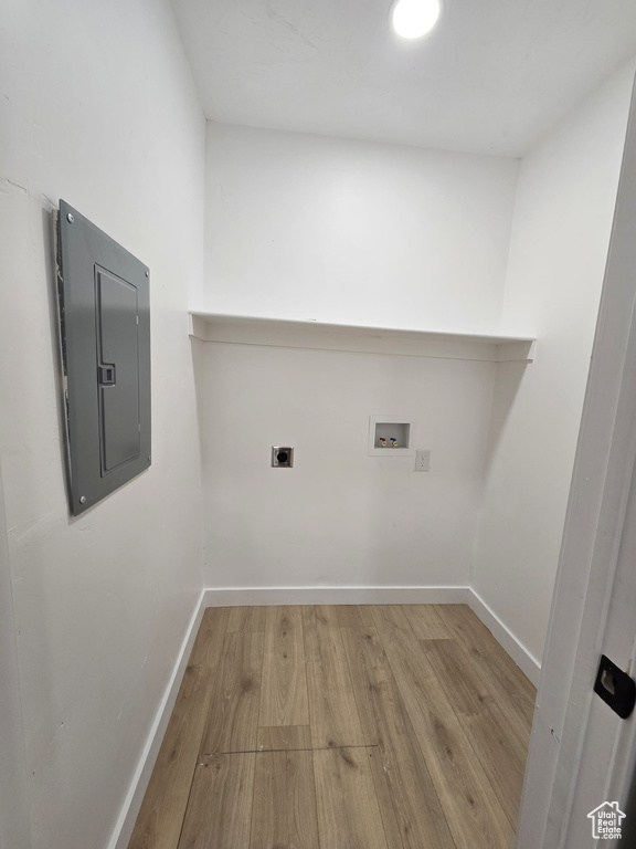 Washroom with electric panel, wood finished floors, washer hookup, and baseboards