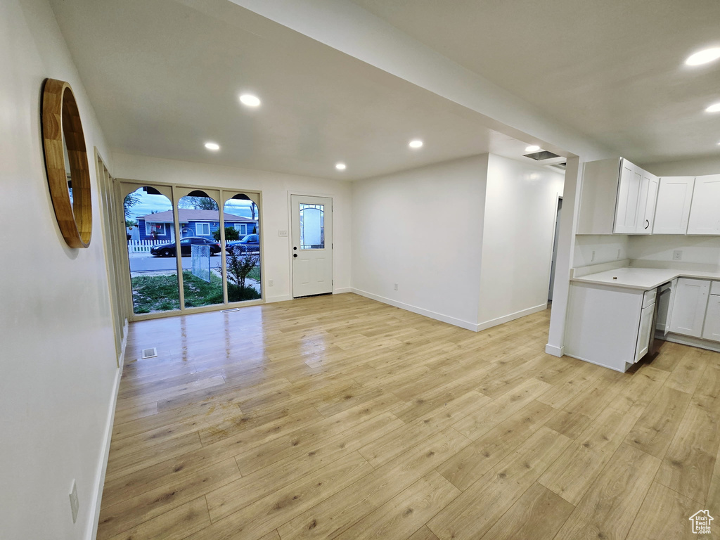 Kitchen featuring open floor plan, baseboards, light wood-style floors, recessed lighting, and white cabinets