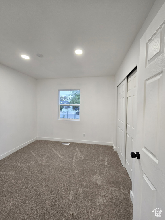 Unfurnished bedroom featuring carpet floors, baseboards, recessed lighting, and a closet
