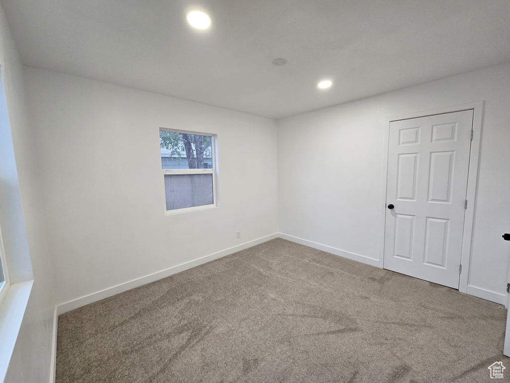 Carpeted spare room with baseboards and recessed lighting