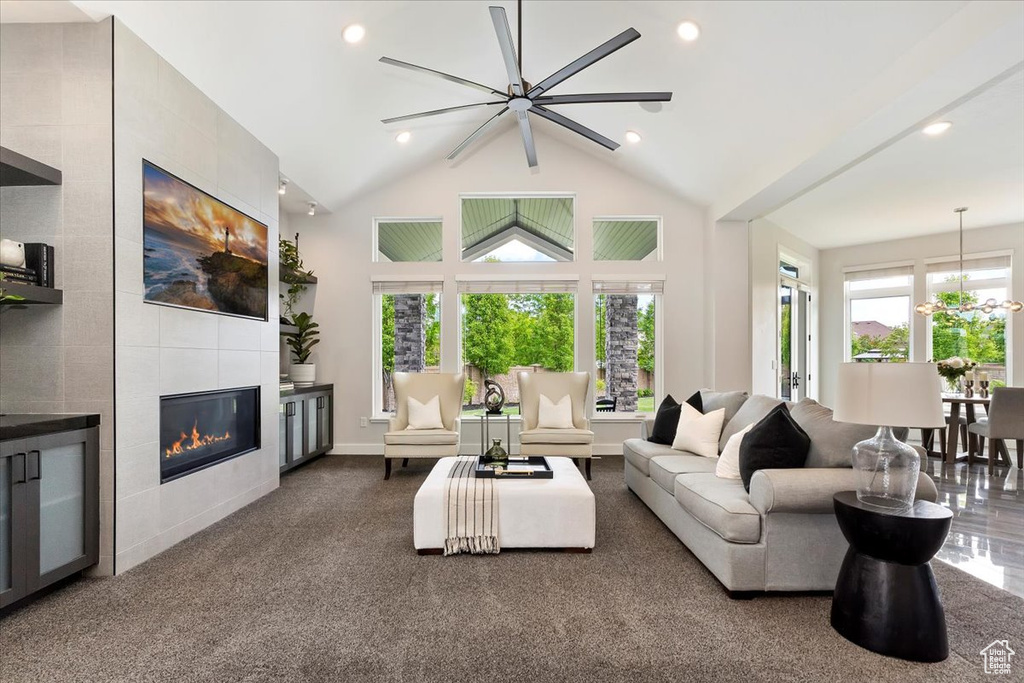 Living area with a tile fireplace, high vaulted ceiling, recessed lighting, and baseboards