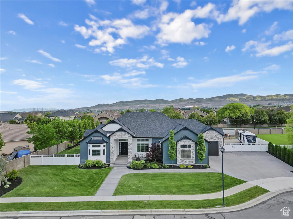 View of front of house featuring stone siding, driveway, and a mountain view