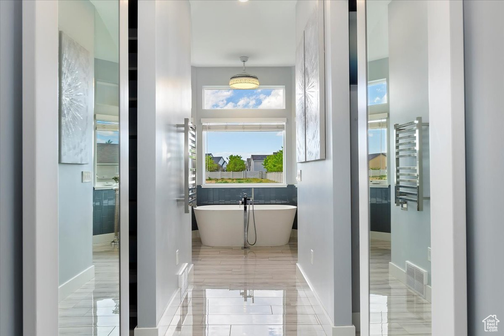 Bathroom featuring a freestanding bath and baseboards