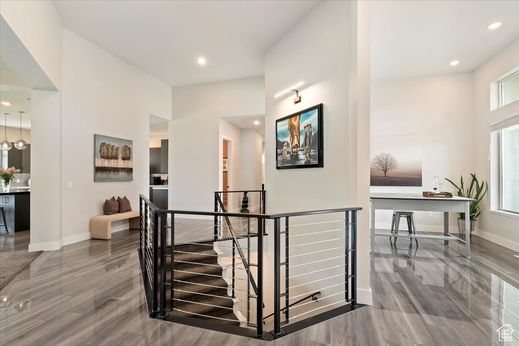 Corridor with an upstairs landing, wood finished floors, healthy amount of natural light, baseboards, and recessed lighting