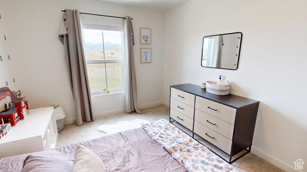 Bedroom featuring light carpet and baseboards