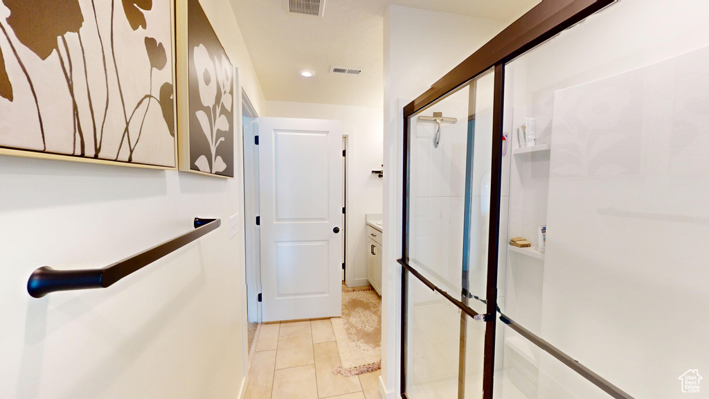 Hallway with light tile patterned flooring and recessed lighting