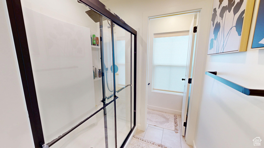 Full bath featuring a stall shower, tile patterned floors, and baseboards