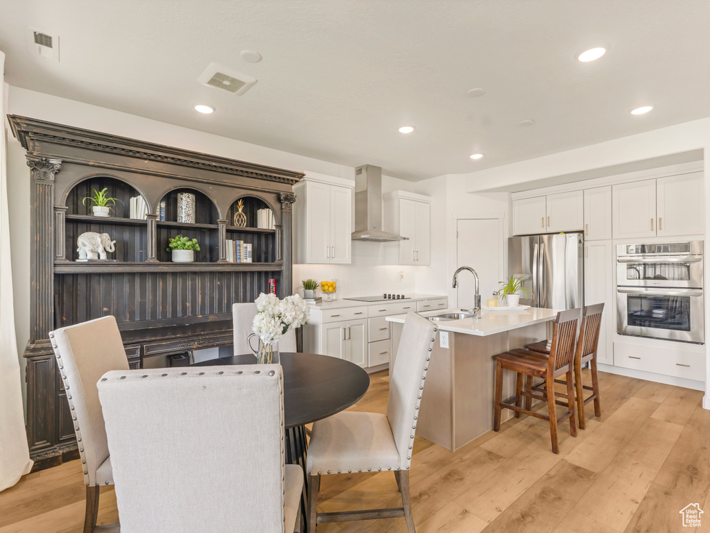 Dining space with light wood-style flooring and recessed lighting