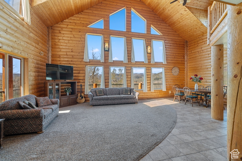 Living room with high vaulted ceiling, log walls, and wood ceiling