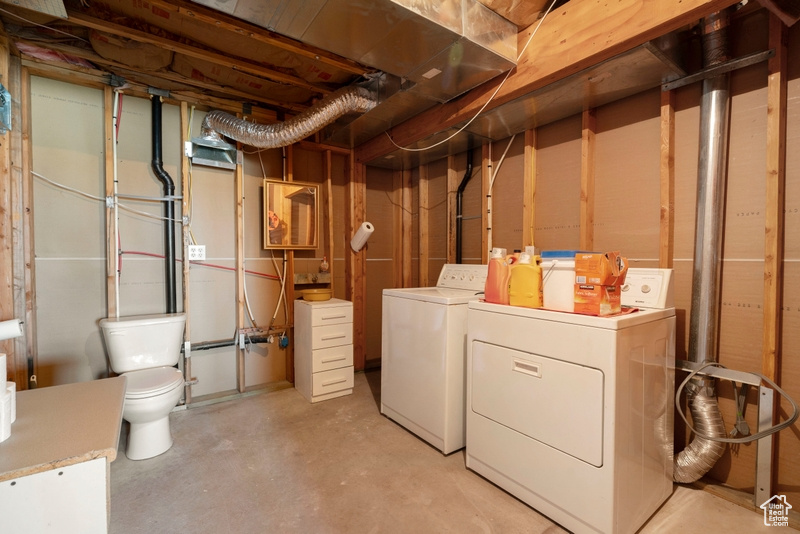 Unfinished below grade area featuring washer and dryer