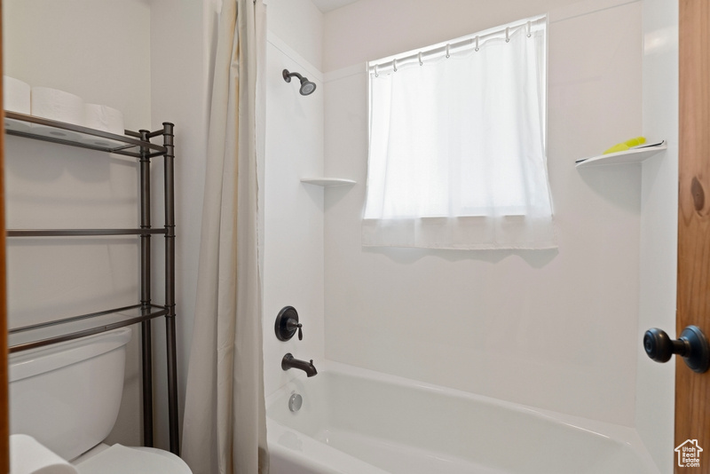 Full bath featuring shower / tub combo and toilet