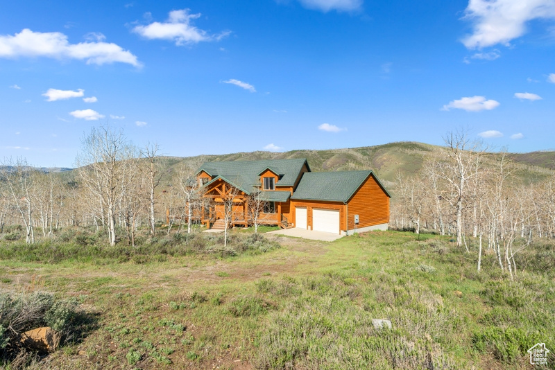 View of side of home featuring a garage, driveway, and a mountain view