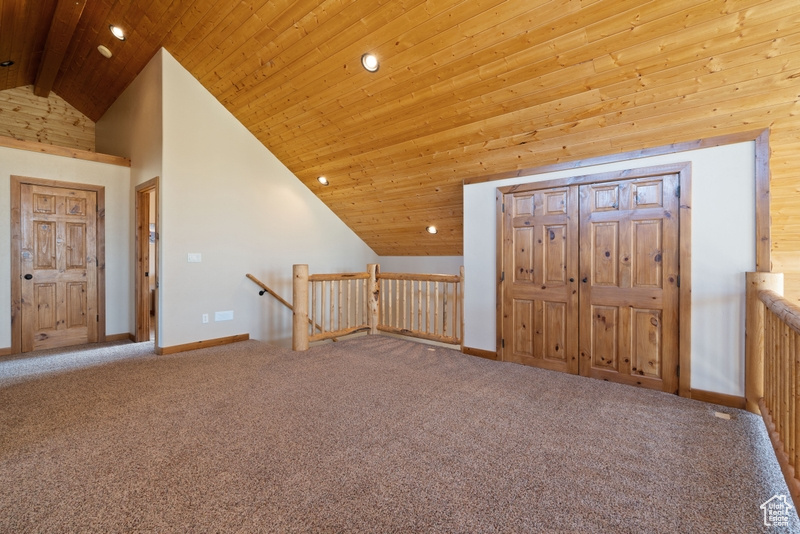 Carpeted entryway with recessed lighting, high vaulted ceiling, wooden ceiling, and baseboards