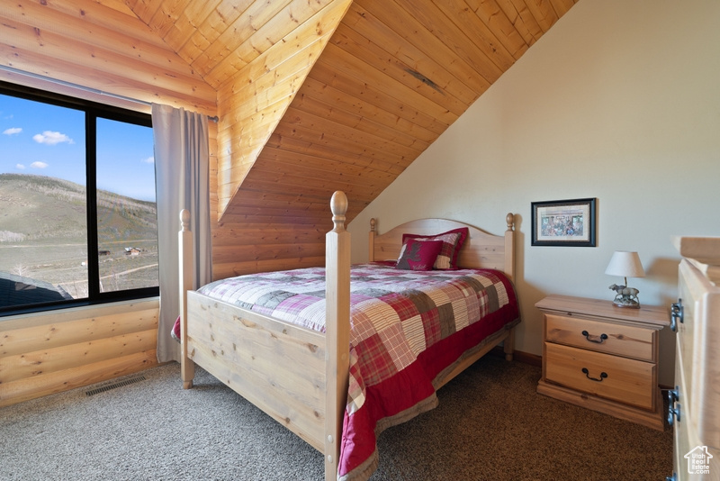 Bedroom featuring lofted ceiling, wooden ceiling, carpet floors, and a mountain view