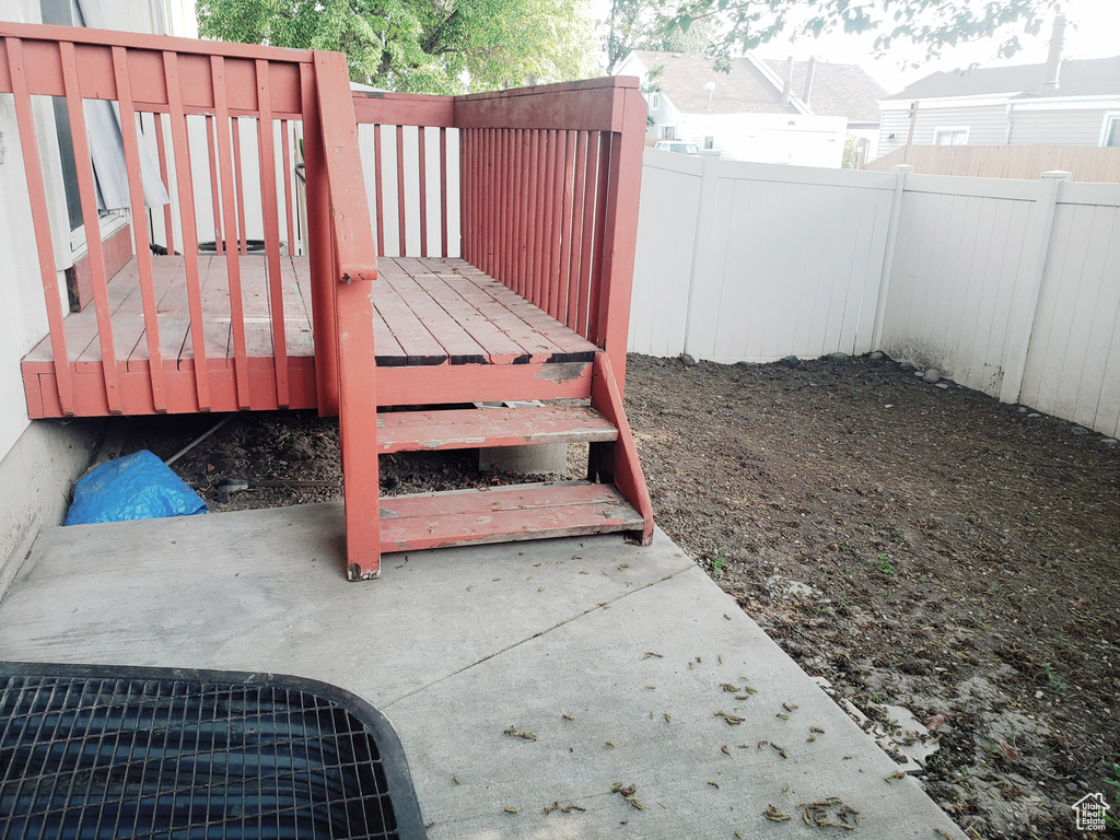 Wooden terrace with a fenced backyard