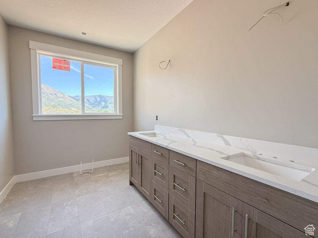 Bathroom featuring baseboards and double vanity