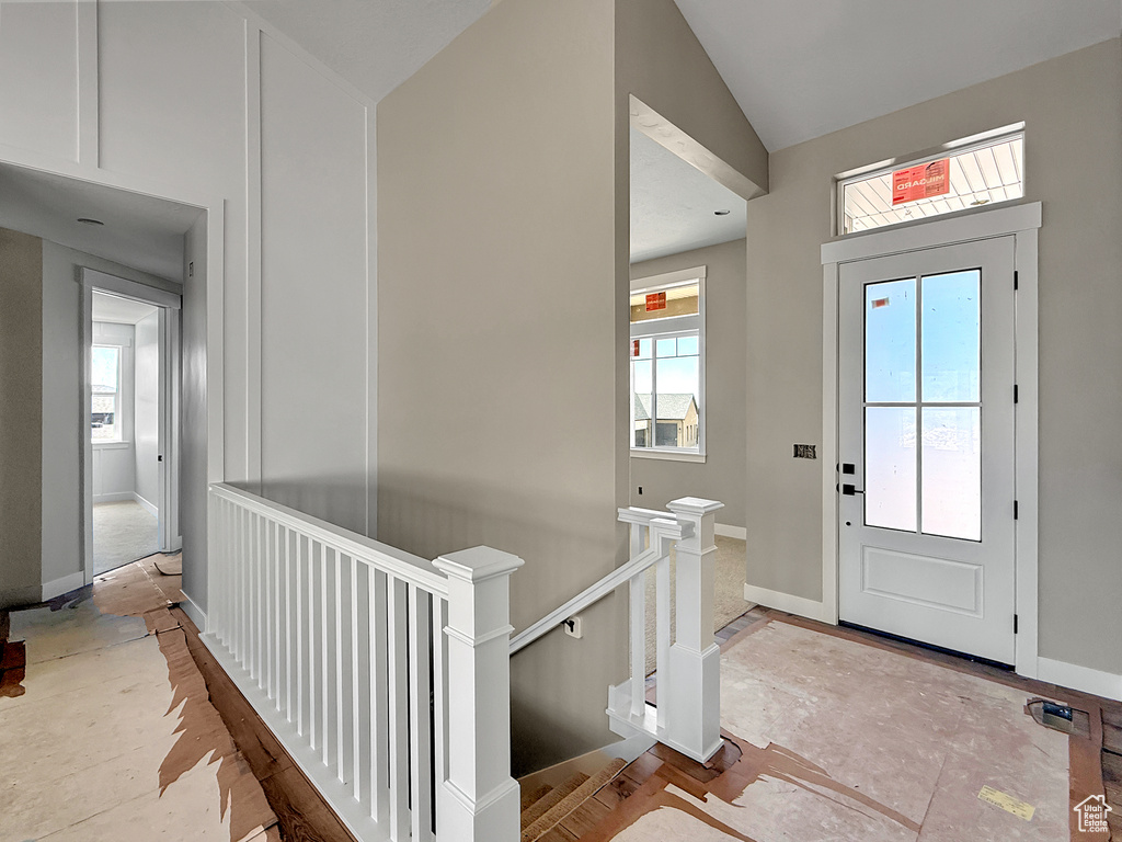 Entryway featuring lofted ceiling and baseboards