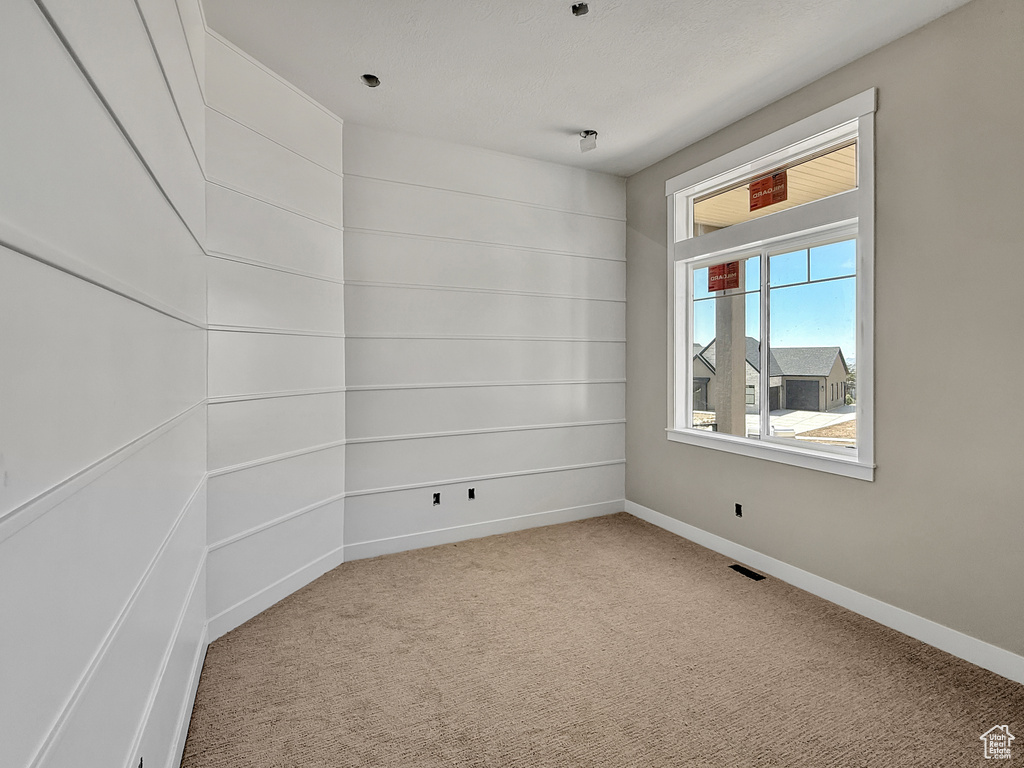 Carpeted empty room featuring baseboards