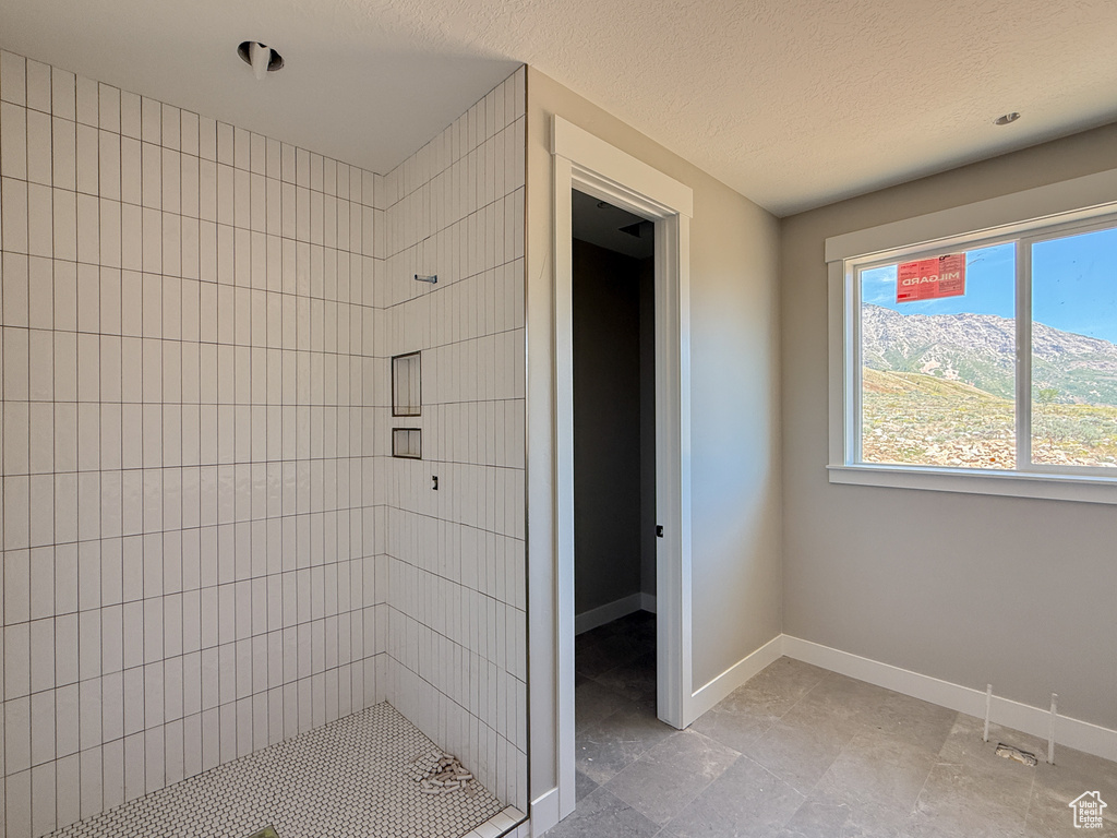 Full bathroom with a stall shower and baseboards