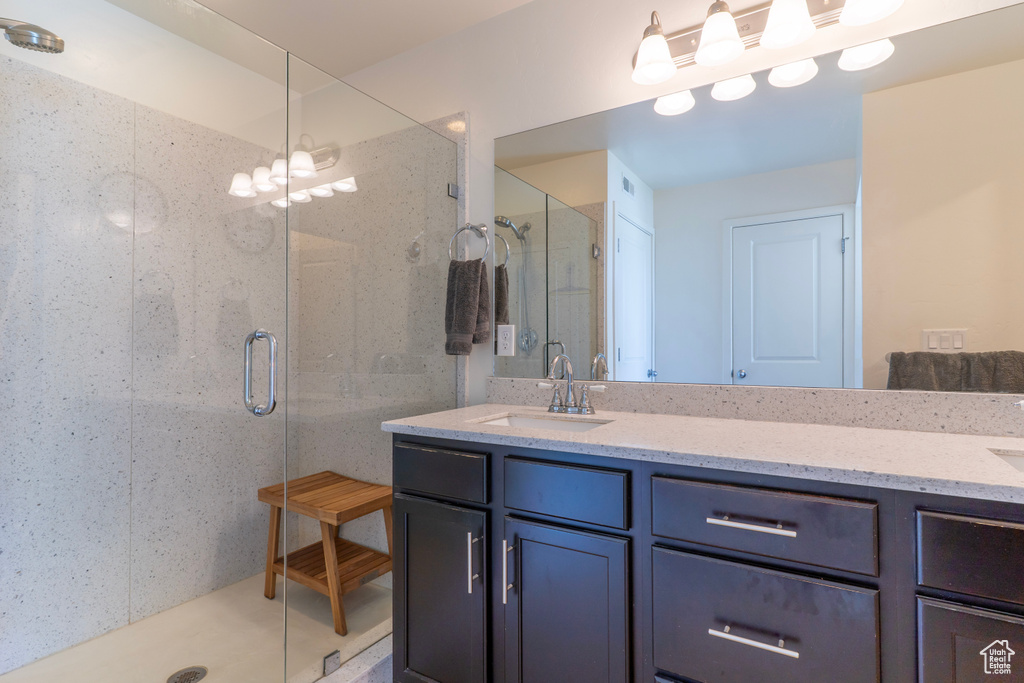 Full bath with double vanity and a shower stall