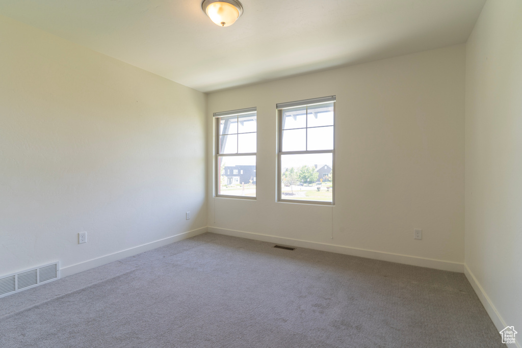 Unfurnished room with light colored carpet and baseboards