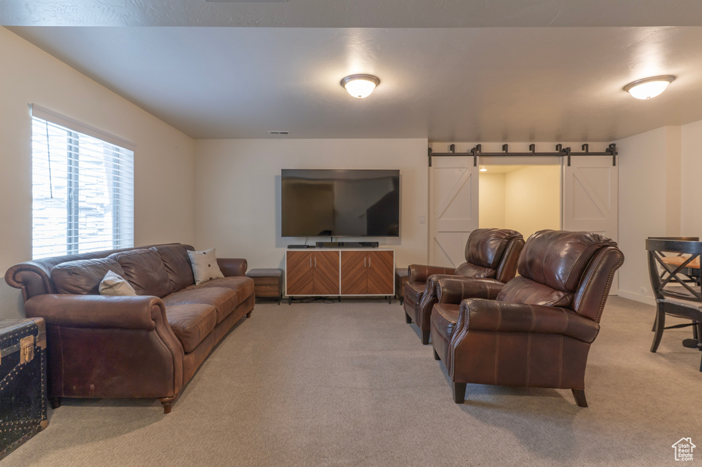Living room featuring light colored carpet and a barn door