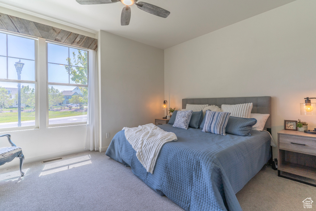Bedroom featuring carpet floors, multiple windows, and ceiling fan