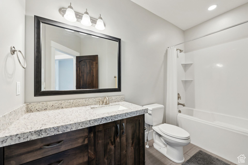Full bathroom featuring toilet, vanity,  shower combination, and tile patterned floors