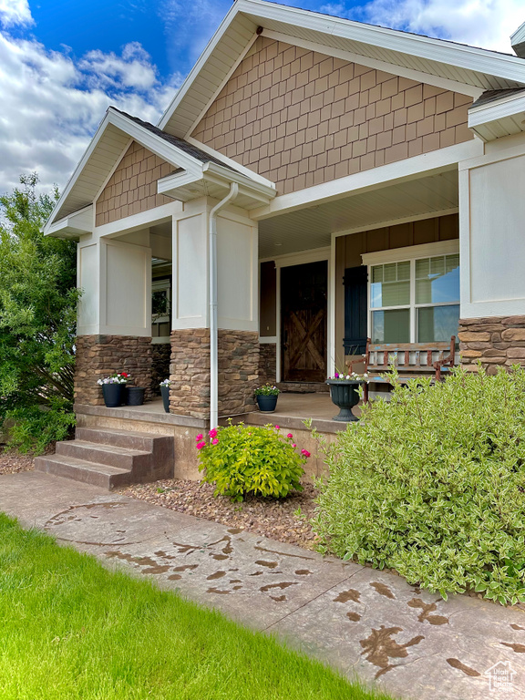 Entrance to property featuring a porch and stone siding