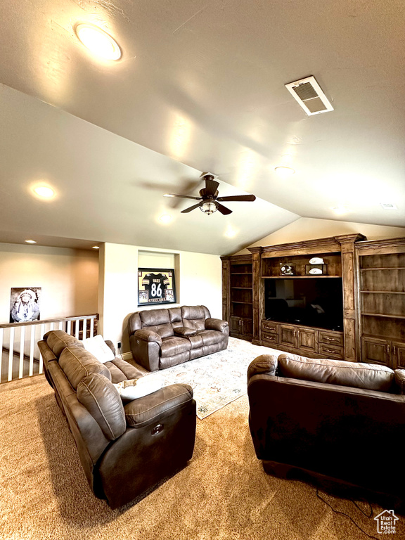 Carpeted living area featuring a ceiling fan and vaulted ceiling