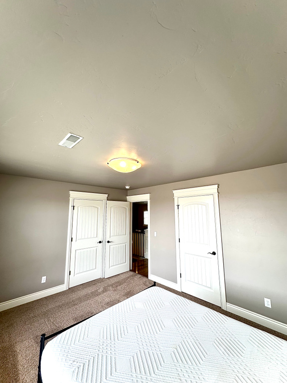 Unfurnished bedroom with baseboards and carpet flooring