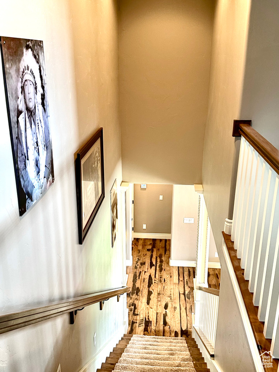 Staircase with baseboards and wood finished floors