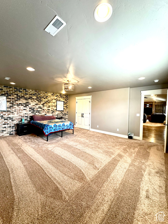 Unfurnished bedroom featuring carpet, baseboards, recessed lighting, brick wall, and ceiling fan
